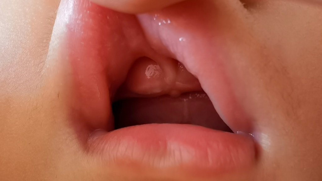 Dente do Bebê Nascendo e a mãe puxando o lábio do bebê para mostrar a gengiva