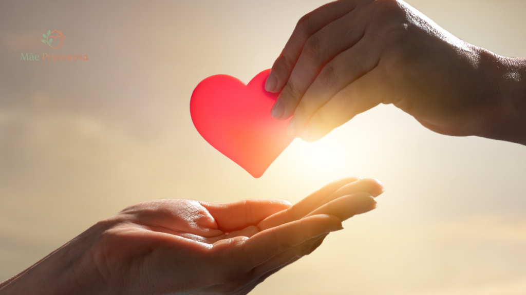 Uma mão entregando um coração de papel vermelho para a outra, para ilustrar o post que discute Como Ensinar Caridade para os Filhos na Quaresma