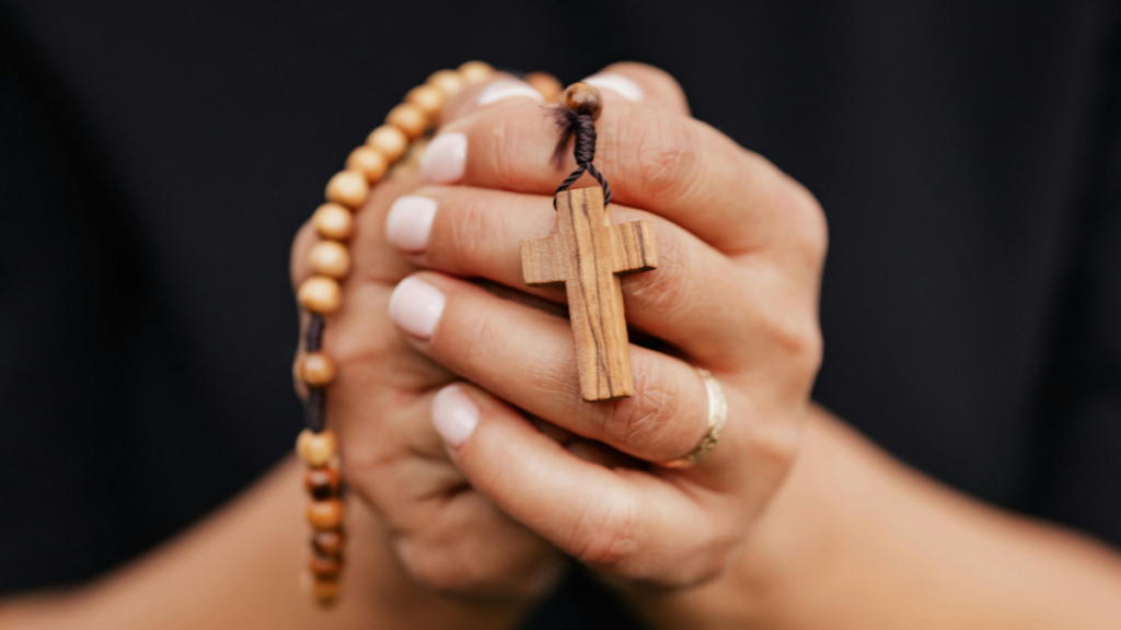 Mãos unidas em oração segurando um terço catórico para leitura de Versículos Bíblicos para Fortalecer Mães no Deserto Espiritual