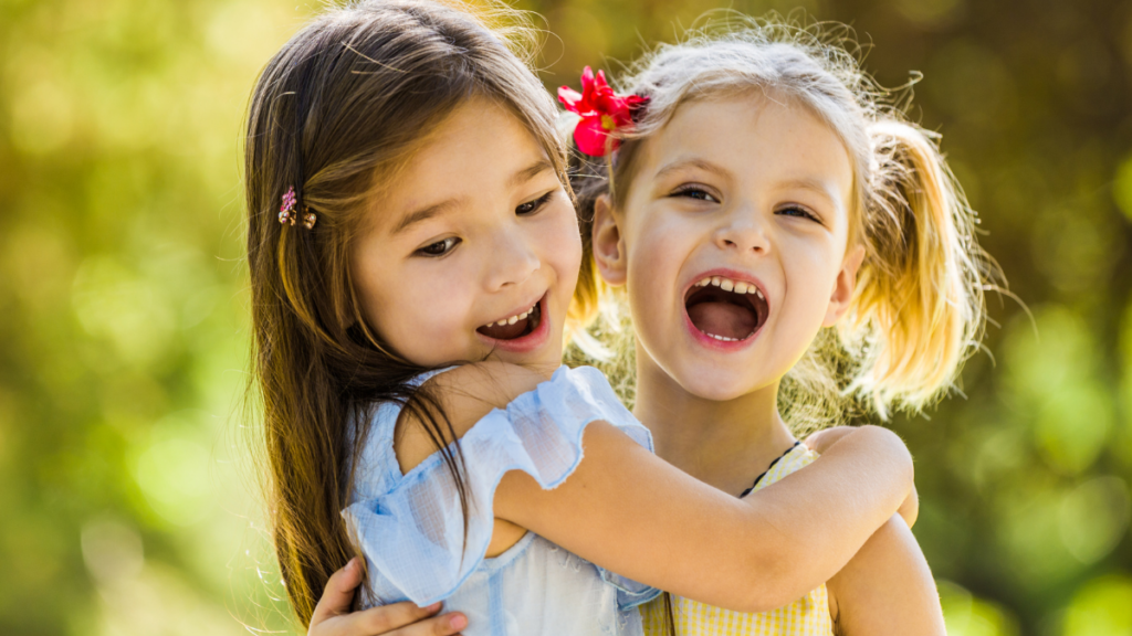 Duas crianças sorrindo abraçadas. Como Explicar o Significado da Quaresma para Crianças.